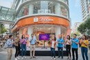 Uma fachada de uma loja da empresa "Shopee" com algumas pessoas cantando karaoke com microfone em mãos